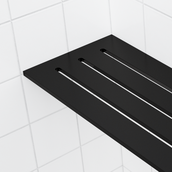 The 4 × 8 in corner shelf in matte black, seen close up, its sharp front edge and three drainage slots.