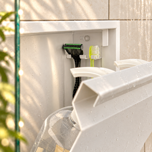 Close-up of the inside of the door niche, 12 × 12 in door, glossy white: hooks holding a razor, a toothbrush and a bottle