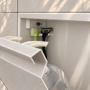 Close-up of the inside of the door niche, 12 × 24 in door, matte white: hooks holding a razor, a toothbrush and a bottle