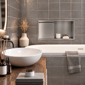 Bathroom with a door niche, 12 × 24 in, brushed stainless steel, recessed above a bathtub, white vessel sink in the foreground