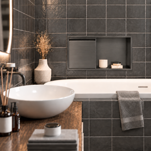 Bathroom with a door niche, 12 × 24 in, black PVD, recessed above a bathtub, white vessel sink in the foreground