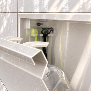 Close-up of the inside of the door niche, 12 × 48 in door, glossy white: hooks holding a razor, a toothbrush and a bottle
