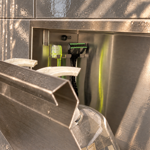 Close-up of the inside of the door niche, 12 × 48 in door, brushed stainless steel: hooks holding a razor, a toothbrush and a bottle