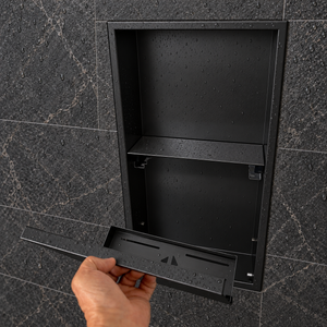 A hand lifts the removable door off the door niche, 24 × 12 in, matte black