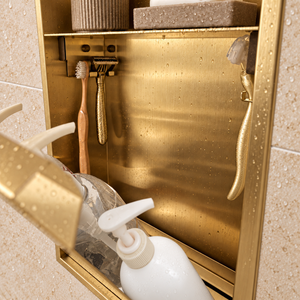 Close-up of the inside of the door niche, 24 × 12 in door, gold PVD: hooks holding a razor, a toothbrush and a bottle