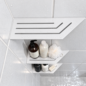 Corner shelf, 4 × 12 in, matte white, bottles and a shower puff on the lower shelves, in a tiled shower