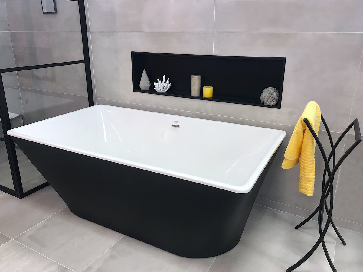 Niche Alba 12 × 48 po en noir mat encastrée dans un mur gris, au-dessus d’une baignoire noire et blanche, objets décoratifs sur la tablette