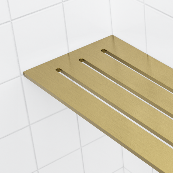Long slots run toward the back, brushed brass and gold PVD on the 4 × 8 in corner shelf seen close up.