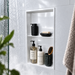 Acia wall niche, 24 × 12 in, glossy white, recessed in a shower wall, bottles and soap stored inside