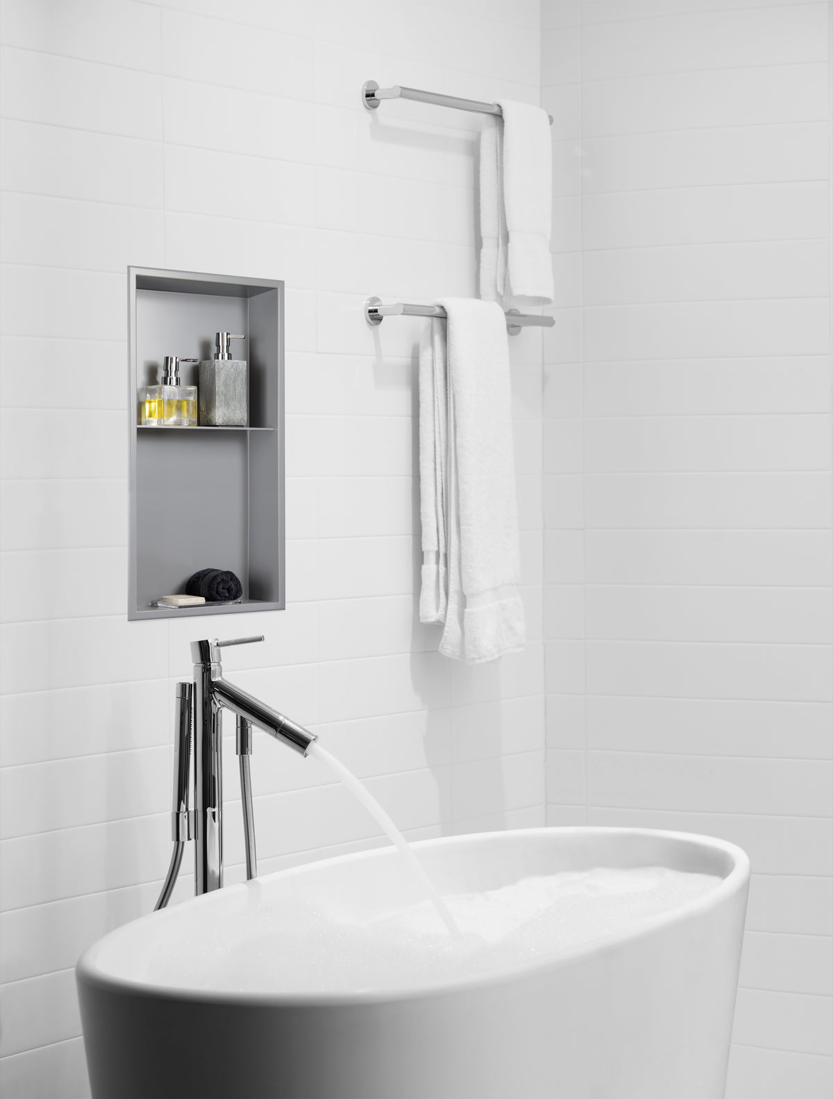 Acia wall niche, 24 × 12 in, matte gray, in a white ceramic wall beside a freestanding tub faucet