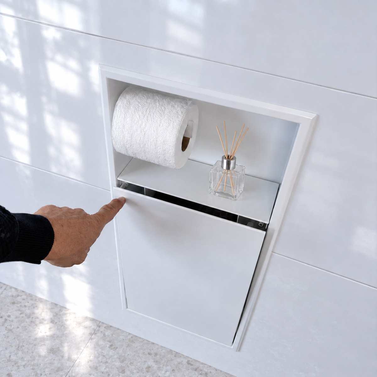 Une main appuie sur la porte de la niche WC blanc lustré 24 × 10,5 po : elle s'ouvre par simple pression