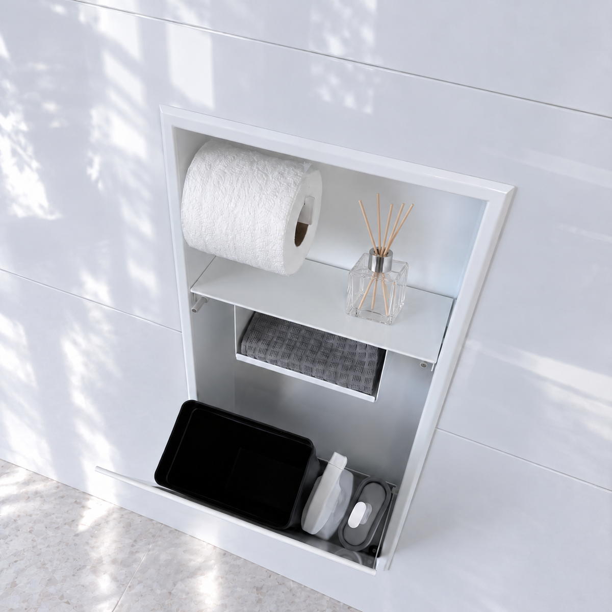 Porte grande ouverte sur la niche WC blanc lustré 24 × 10,5 po : bac noir et accessoires de nettoyage rangés dans le compartiment du bas