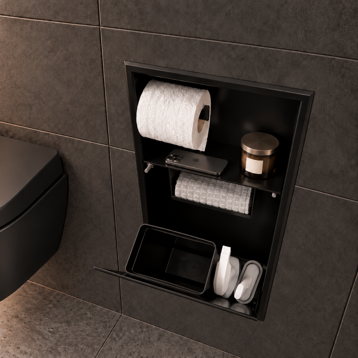 Porte grande ouverte sur la niche WC noir mat 24 × 10,5 po : bac noir et accessoires de nettoyage rangés dans le compartiment du bas