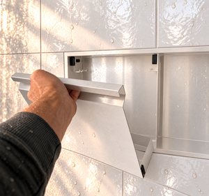 A hand lifts the removable door off the door niche, 12 × 48 in, glossy white