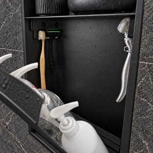 Close-up of the inside of the door niche, 24 × 12 in door, matte black: hooks holding a razor, a toothbrush and a bottle