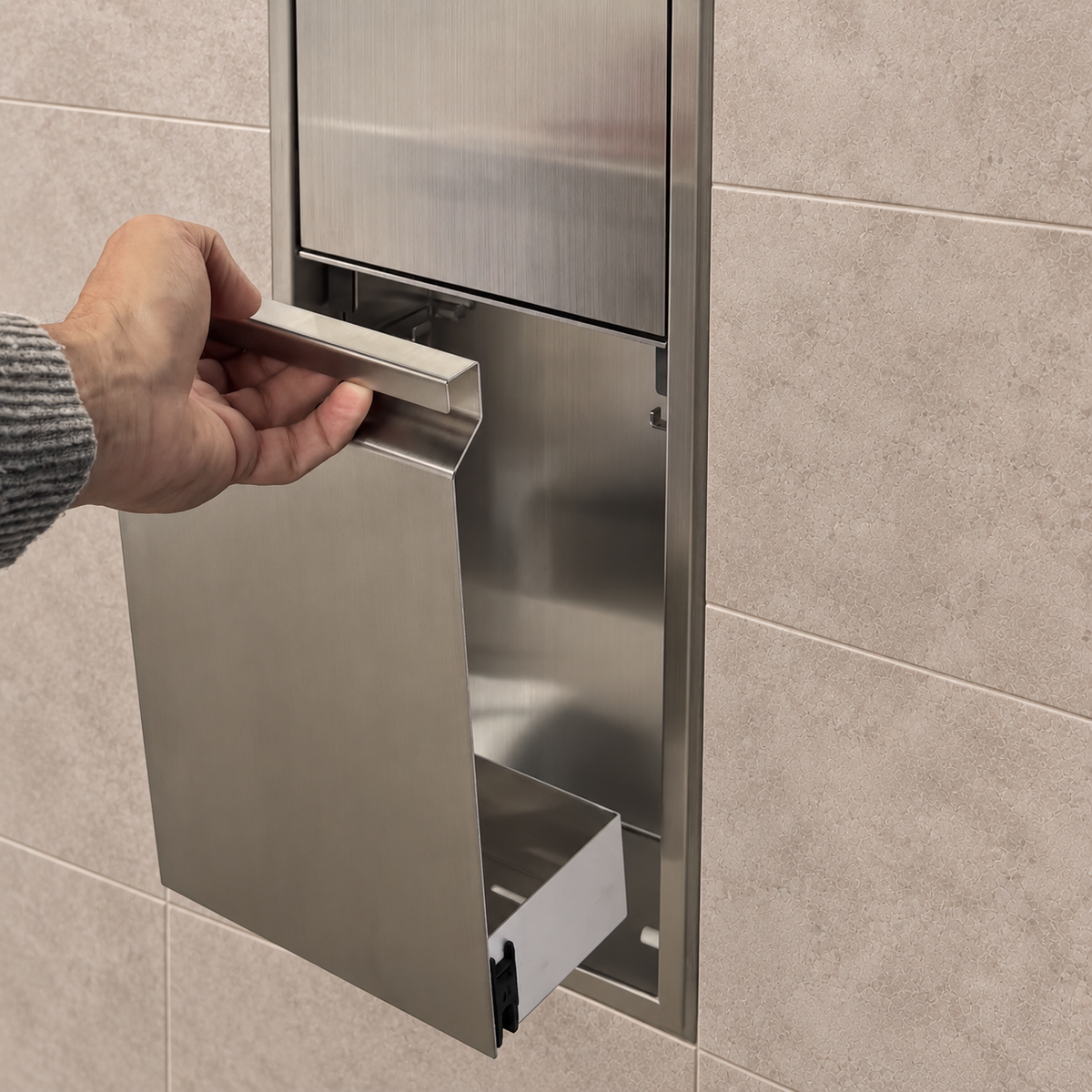 A hand lifts the removable door off the door niche, 36 × 8 in, brushed stainless steel