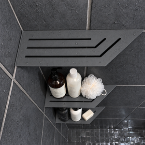 Corner shelf, 4 × 12 in, matte gray, bottles and a shower puff on the lower shelves, in a tiled shower