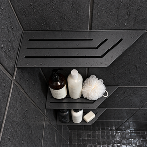 Corner shelf, 4 × 12 in, matte black, bottles and a shower puff on the lower shelves, in a tiled shower